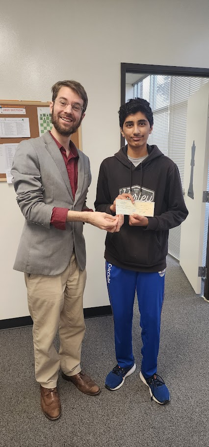 Aaryan receiving a chess prize check